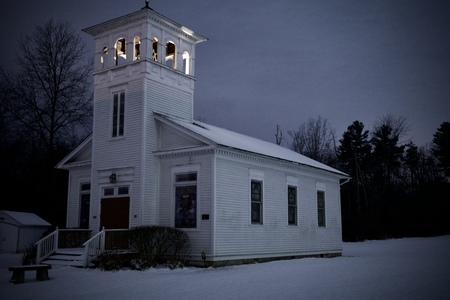 A historic church with an illuminated bell tower.