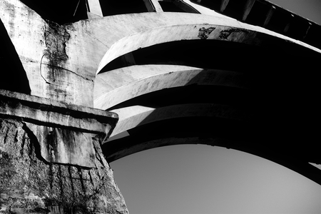 A concrete bridge with erosion exposing rebar.