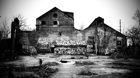 A wall with graffiti in the courtyard of an abandoned building.