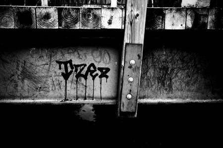 A tag on the side of a small footbridge.